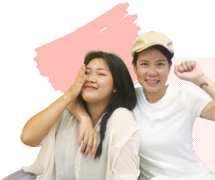 Two smiling Asian women, one holding her fist in the air with joy