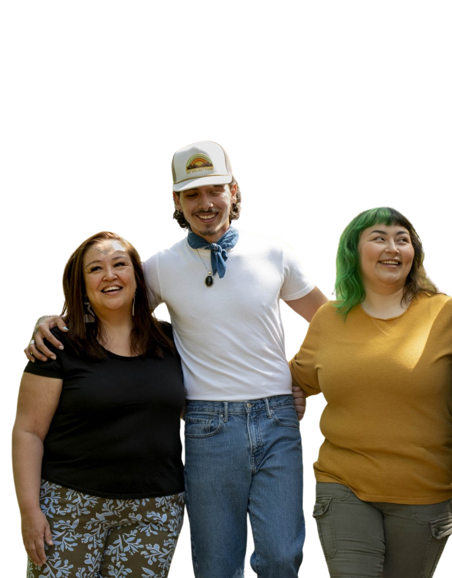 Three Indigenous people smiling and standing together with arms around each other.